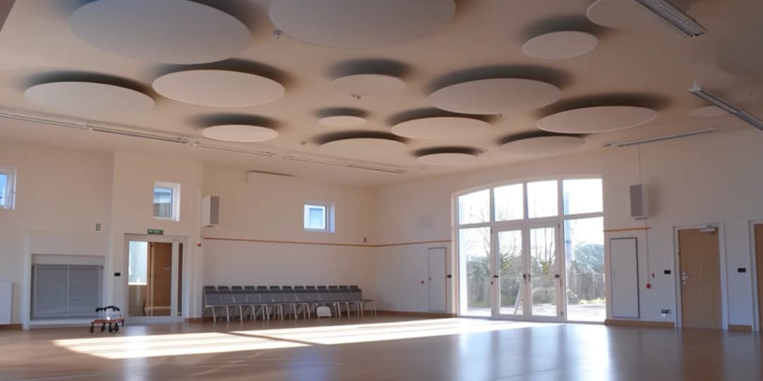 new village hall community space with acoustic ceiling rafts suspended from the ceiling, laminated floor and high ceilings