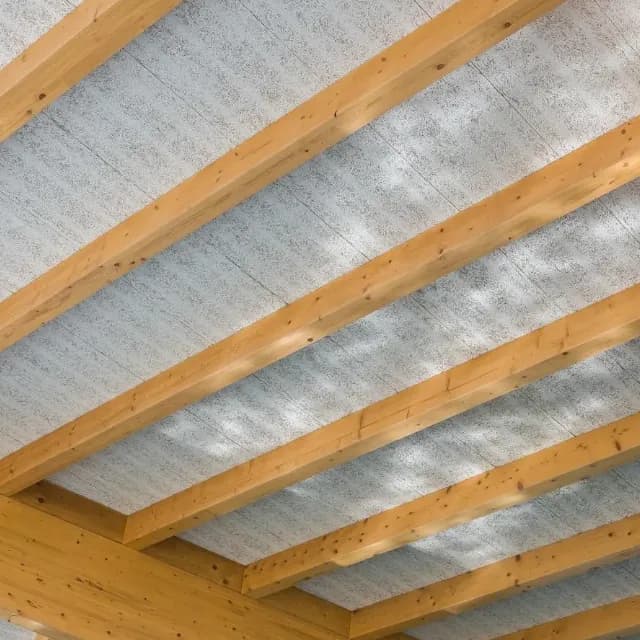 acoustic swimming pool ceiling installed in between wooden beams with light reflecting off pool on to panels