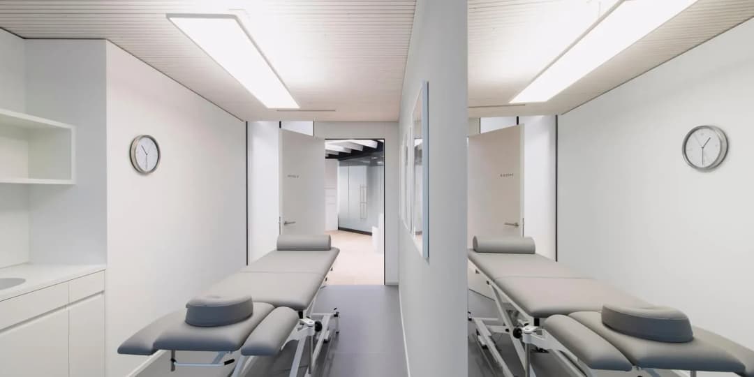 two rooms in private healthcare facility, treatment beds with clinical look and ribbed acoustic ceiling to help privacy