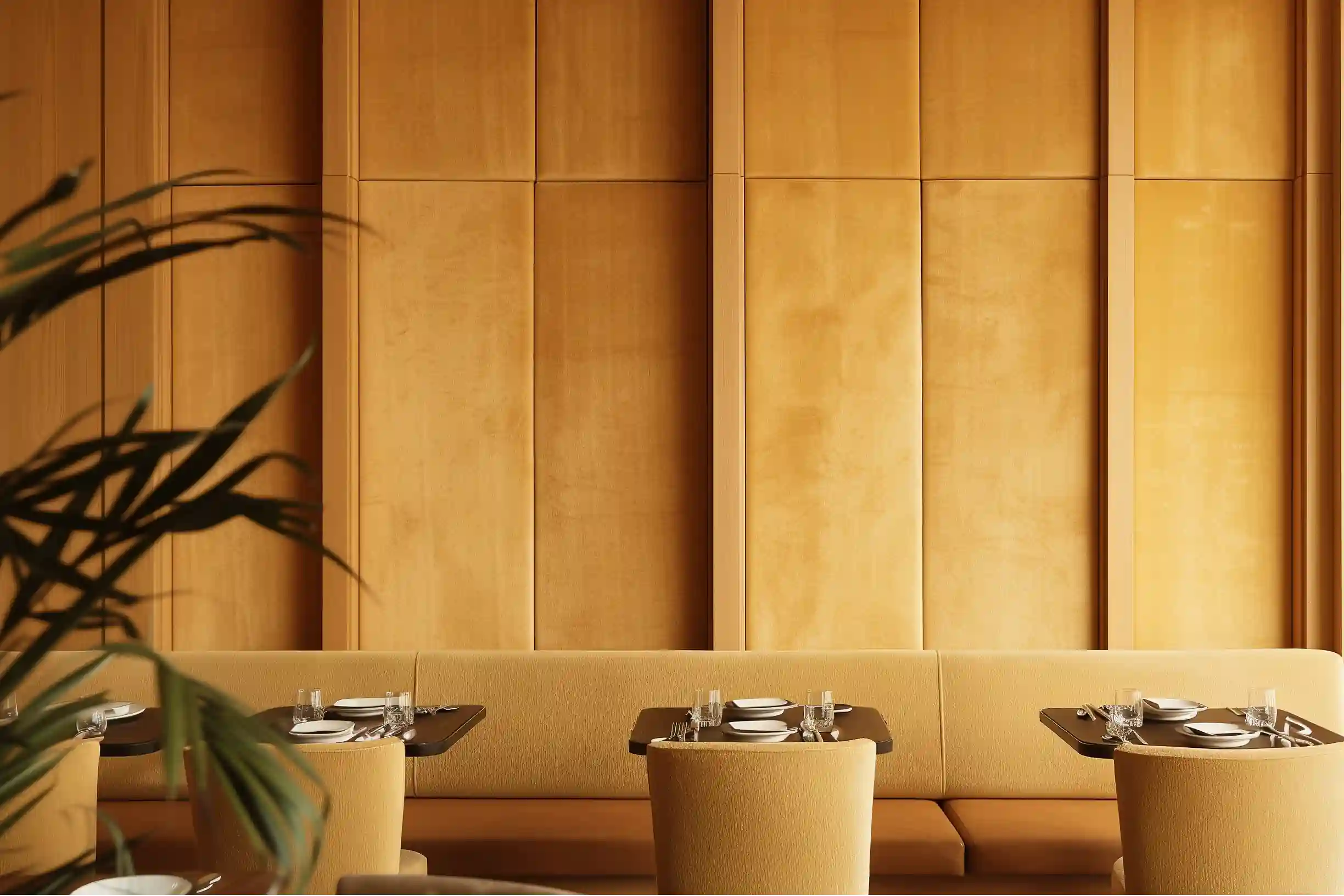 modern restaurant with small tables and banquette seating. above the seating are velvet fabric wrapped acoustic wall panels
