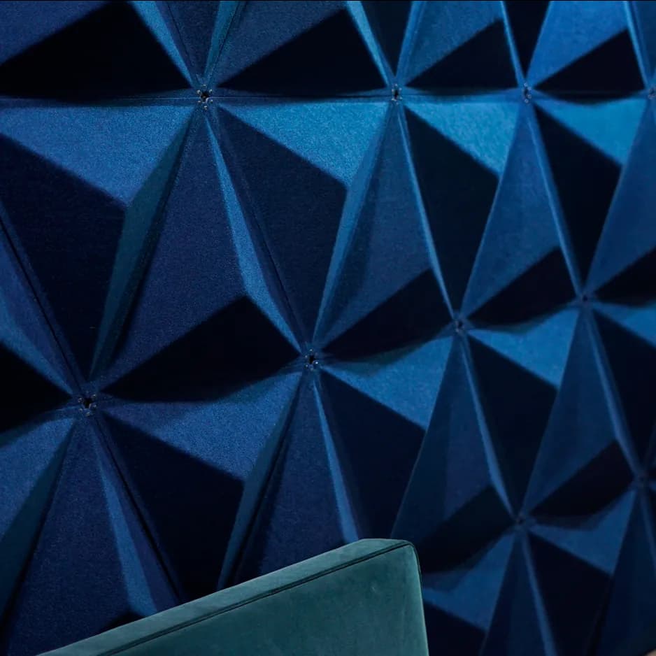 close up of pyramid shaped acoustic panels in a studio setting, they are dark blue with a velvet finish