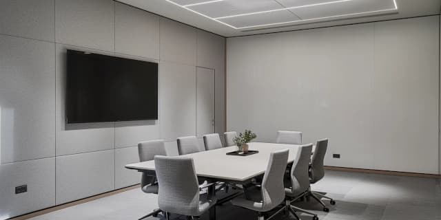 a commercial office meeting room with grey fabric stretched fabric acoustic wall panelling to reduce reverberation