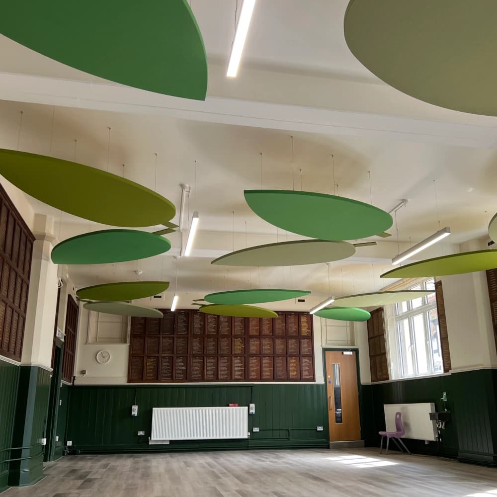 school dining room with green leaf shaped acoustic ceiling rafts suspended from the ceiling